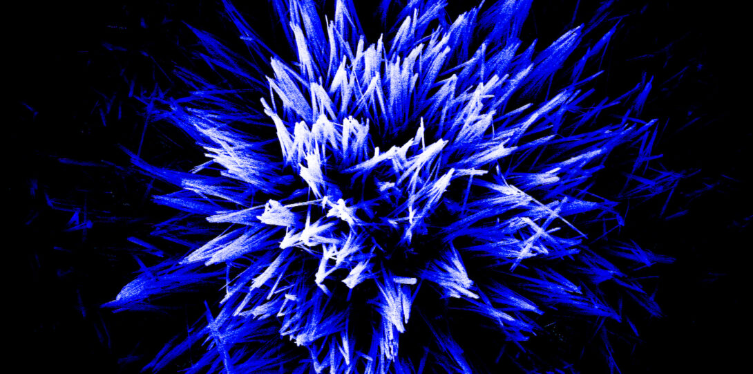 A cluster of blue and white spikes point towards the camera on a black background.