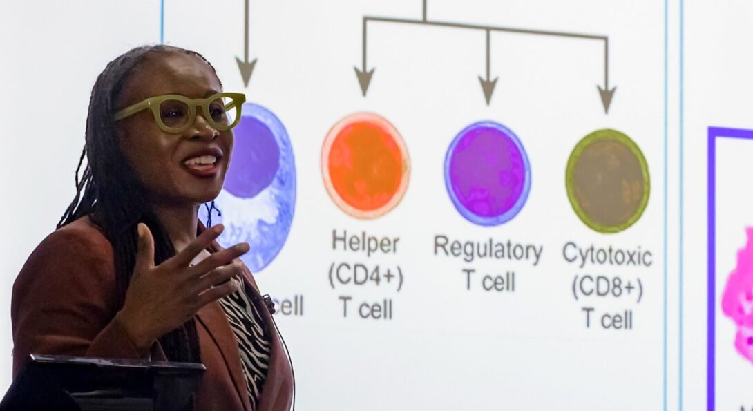 Lola Eniola-Adefeso speaks in front of a screen showing types of white blood cells.