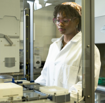 A female scientist operates a mass spectrometry robot instrument.
                  