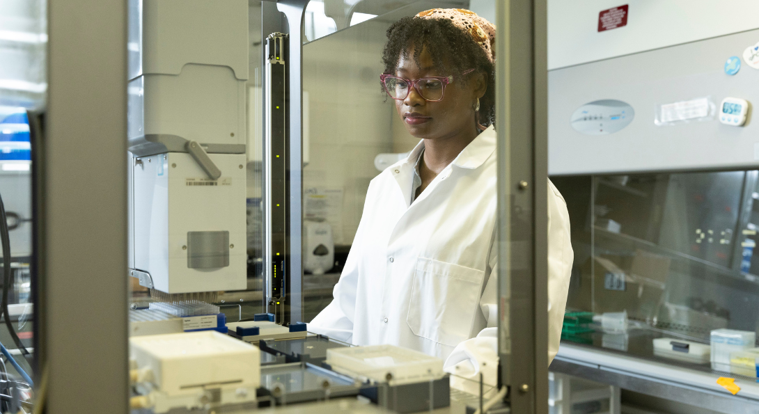 A female scientist operates a mass spectrometry robot instrument.